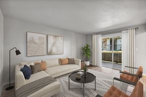 Livermore apartment for rent - A living room with a white couch, a black coffee table, and a brown chair.