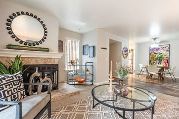 Sacramento apartment for rent - A living room with a fireplace, a sofa, a coffee table, and a painting on the wall.