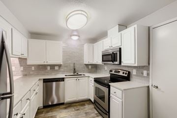 Vancouver apartment for rent - A kitchen with white cabinets and appliances.