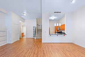 Tigard apartment for rent - A spacious room with wooden floors and white walls.