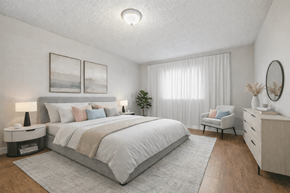 San Leandro apartment for rent - A well-lit bedroom with a large bed, a chair, and a side table.