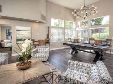 Sacramento apartment for rent - A living room with a pool table and a large window.