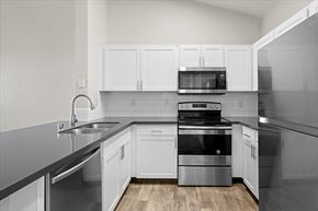 Reno apartment for rent - A modern kitchen with white cabinets and stainless steel appliances.