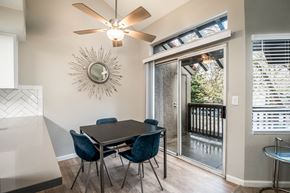 Sacramento apartment for rent - A dining room with a table and chairs and a fan on the wall.