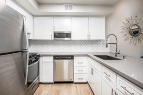 Sacramento apartment for rent - A modern kitchen with white cabinets and stainless steel appliances.