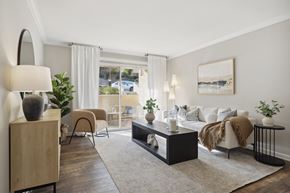 Simi Valley apartment for rent - A modern living room with a large window, a sofa, and a coffee table.