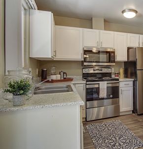Sparks apartment for rent - a kitchen with stainless steel appliances and white cabinets