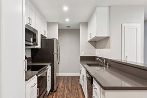 Martinez apartment for rent - A kitchen with white cabinets and dark countertops.