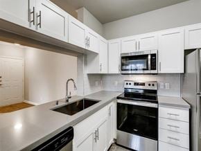 Aliso Viejo apartment for rent - A modern kitchen with white cabinets and stainless steel appliances.