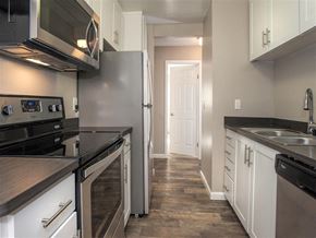 Cupertino apartment for rent - A kitchen with white cabinets and black appliances.