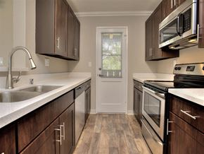 Pacific Grove apartment for rent - A kitchen with dark wood cabinets and stainless steel appliances.