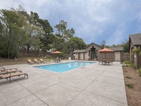 Pacific Grove apartment for rent - A pool surrounded by a concrete patio and a few chairs.