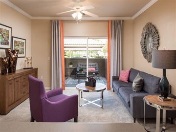Riverside apartment for rent - A living room with a purple chair and a grey couch.