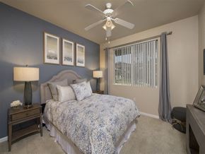 Riverside apartment for rent - A bedroom with a bed, nightstands, and a ceiling fan.