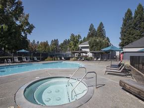 Rohnert Park apartment for rent - A hot tub sits in the middle of a pool surrounded by chairs.