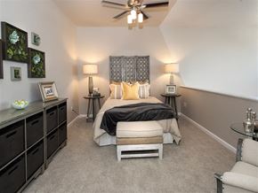Roseville apartment for rent - A bedroom with a bed, nightstands, and a ceiling fan.