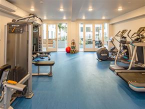 Sacramento apartment for rent - A spacious gym with a variety of equipment including treadmills, elliptical machines, and a weight machine.