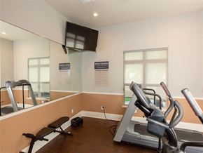 Sacramento apartment for rent - A gym room with a treadmill and a mirror.