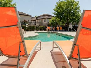 Sacramento apartment for rent - Two orange chairs are facing a pool.