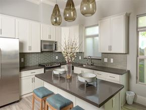Sacramento apartment for rent - A kitchen with white cabinets and a black countertop.