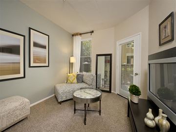 San Jose apartment for rent - A living room with a grey couch, a coffee table, and a painting on the wall.