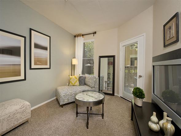 San Jose apartment for rent - A living room with a grey couch, a coffee table, and a painting on the wall.