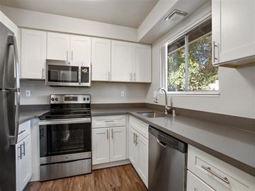 Santa Rosa apartment for rent - A modern kitchen with white cabinets and stainless steel appliances.