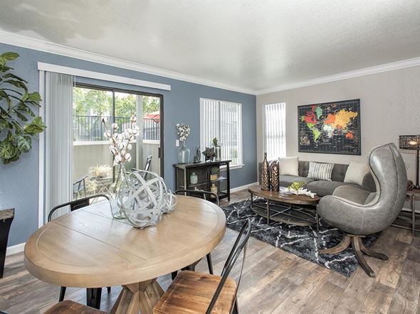 Vacaville apartment for rent - A living room with a round wooden table and a grey armchair.