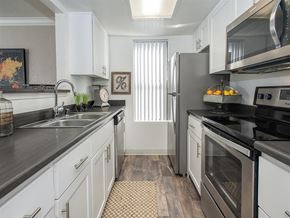 Vacaville apartment for rent - A kitchen with white cabinets and black countertops.
