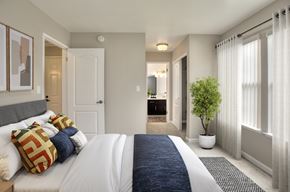 Pacific Grove apartment for rent - A bedroom with a large bed and a potted plant.