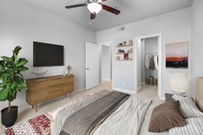 Aliso Viejo apartment for rent - A bedroom with a bed, a ceiling fan, and a cabinet with a TV on the wall.