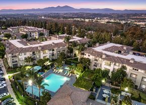 Aliso Viejo apartment for rent - A large apartment complex with a pool and palm trees.