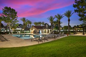 Laguna Niguel apartment for rent - a swimming pool with chairs and a house at dusk