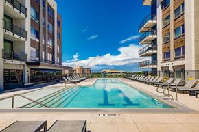 Denver apartment for rent - A large swimming pool in a residential area with sun loungers on the side.