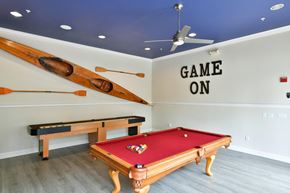 Dublin apartment for rent - A pool table with a red cloth and a wooden frame is in the center of the room.