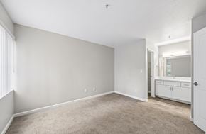 Livermore apartment for rent - A spacious room with a carpeted floor and a small kitchenette in the corner.