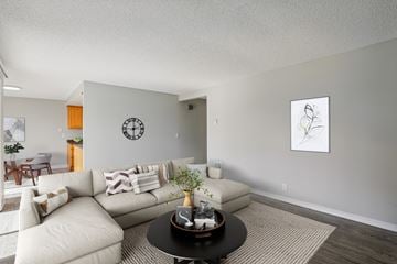 Vancouver apartment for rent - A living room with a white couch and a clock on the wall.