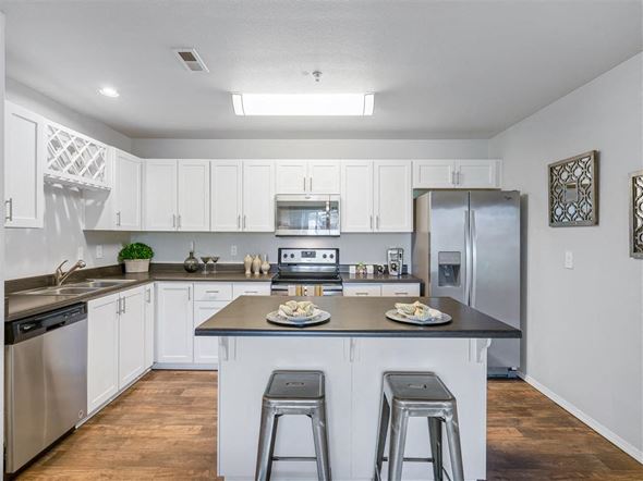 Happy Valley apartment for rent - A kitchen with white cabinets and a black countertop.