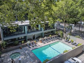 Portland apartment for rent - A swimming pool surrounded by lounge chairs and trees.