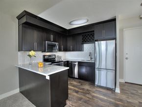 Portland apartment for rent - A kitchen with black cabinets and a white island.