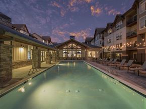 Tigard apartment for rent - A large indoor swimming pool with lounge chairs and a building in the background.