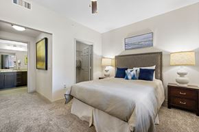 Greenwood Village apartment for rent - A bedroom with a large bed and a painting on the wall.