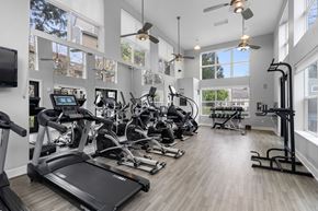 Beaverton apartment for rent - A spacious gym with a variety of equipment and a flat screen TV mounted on the wall.