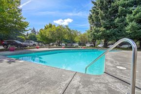 Vancouver apartment for rent - A swimming pool surrounded by trees and a fence.
