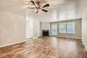Vancouver apartment for rent - A spacious living room with wood flooring and a ceiling fan.