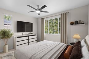 Hillsboro apartment for rent - A bedroom with a large bed, a flat screen TV, and a ceiling fan.