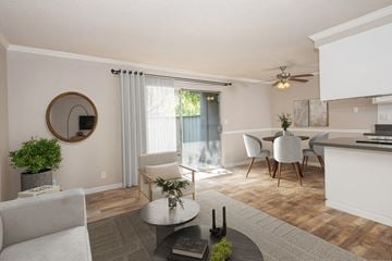 Martinez apartment for rent - A modern living room with a grey sofa, a coffee table, and a dining table set up.