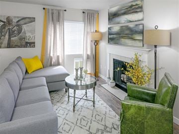 Renton apartment for rent - A grey couch sits in a living room with a green chair and a coffee table.