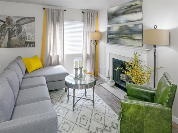 Renton apartment for rent - A grey couch sits in a living room with a green chair and a coffee table.