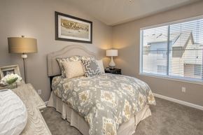 Petaluma apartment for rent - A bedroom with a bed, two lamps, and a painting on the wall.